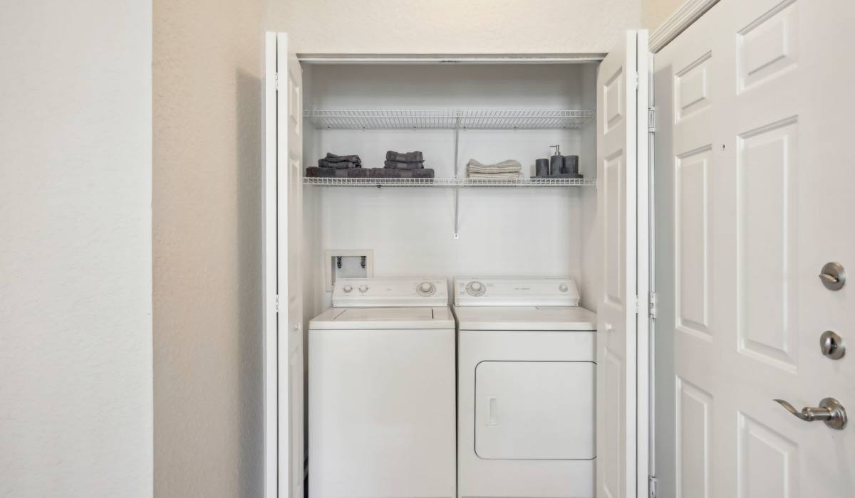 Full-size washer and dryer tucked away in a closet with ample storage at Sole at Citrus Park apartments in Tampa, Florida
