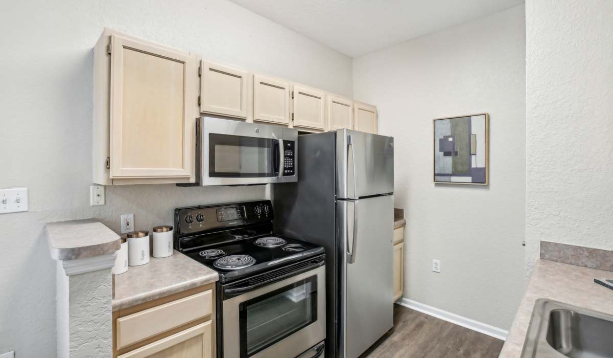 Spacious kitchen with ample counter space and cabinetry and wood style flooring at Sole at Citrus Park apartments in Tampa, Florida.