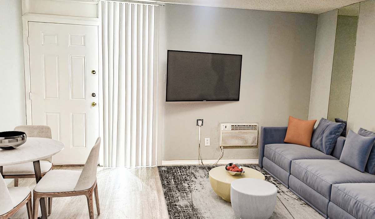A cozy living room featuring a couch, a coffee table, and a television against a neutral wall at Cliffside at Mountain Park in El Paso, Texas