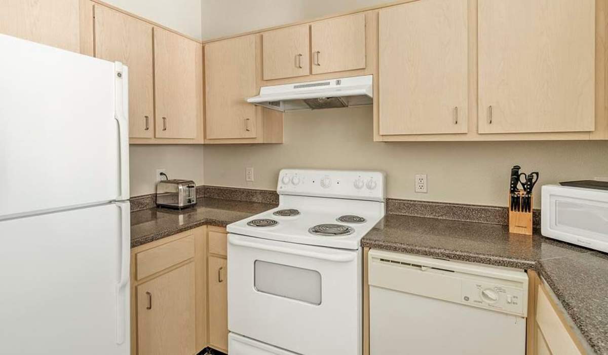 Kitchen with white appliances at Settlers Ranch Apartments in Houston,Texas