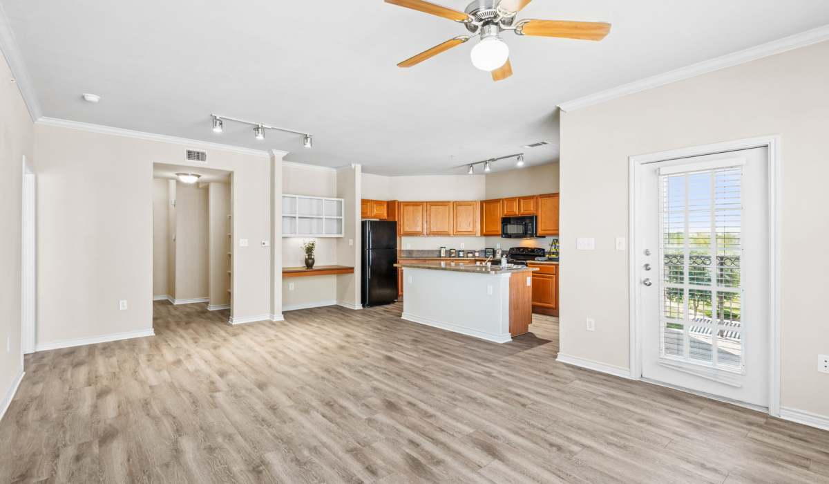 Kitchen and living room with large windows at Park Avenue at Boulder Creek in Houston, Texas 