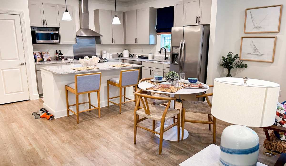 Combined view of the dining area and kitchen at Cottages of Schillinger Pointe in Mobile, Alabama