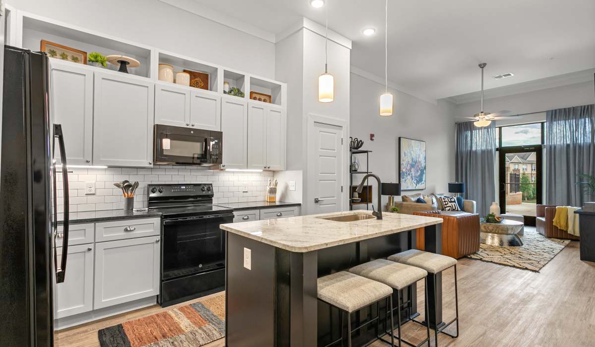 at Kitchen Bar and Living Room with brown leather chair View of kitchen with bar and four barstools at Keystone Mebane Towne Center in Mebane, North Carolina