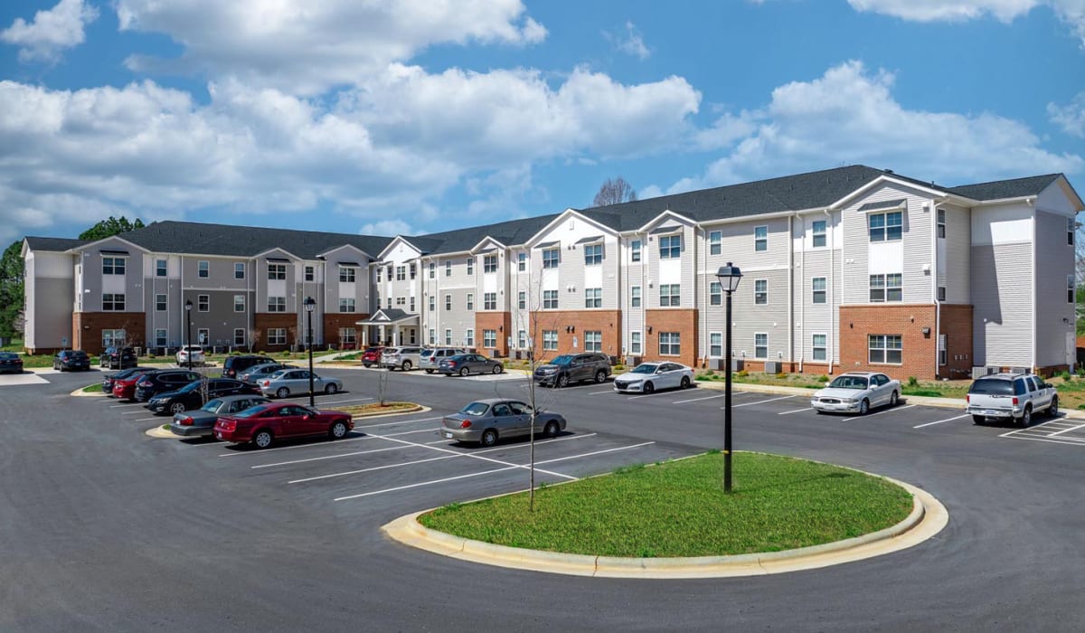 Apartment building exterior with parking lot at Landon Greene in Statesville, North Carolina