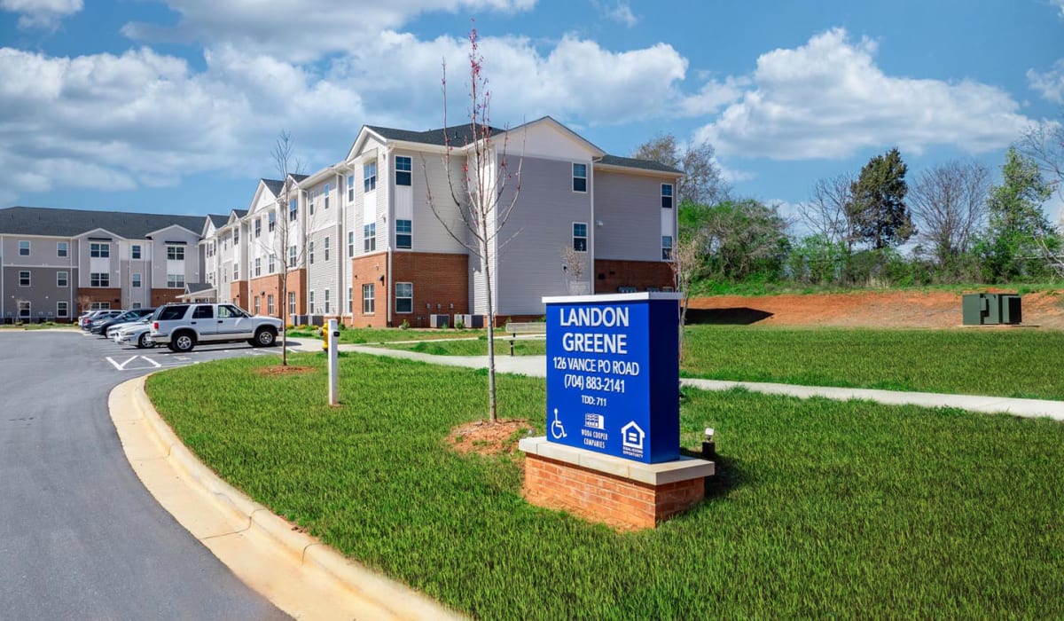 Apartment community exterior with sign and parking at Landon Greene in Statesville, North Carolina