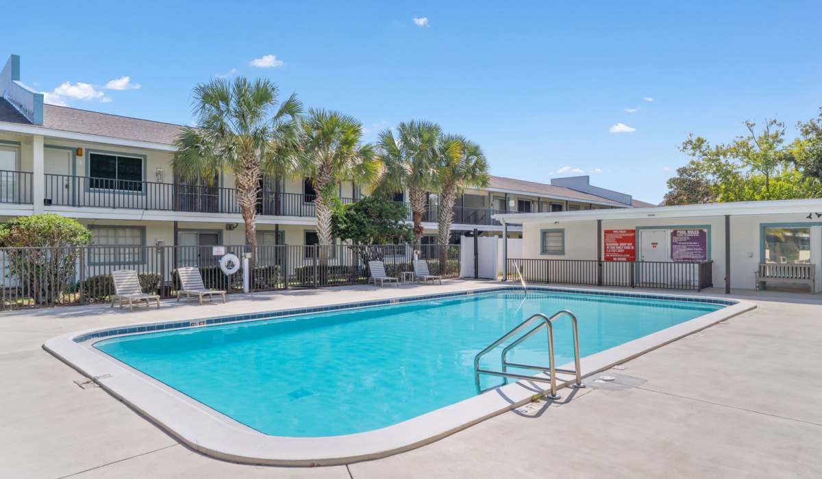 Resort-style pool with lounge chairs at Breeze Apartments in Gulf Breeze, Florida
