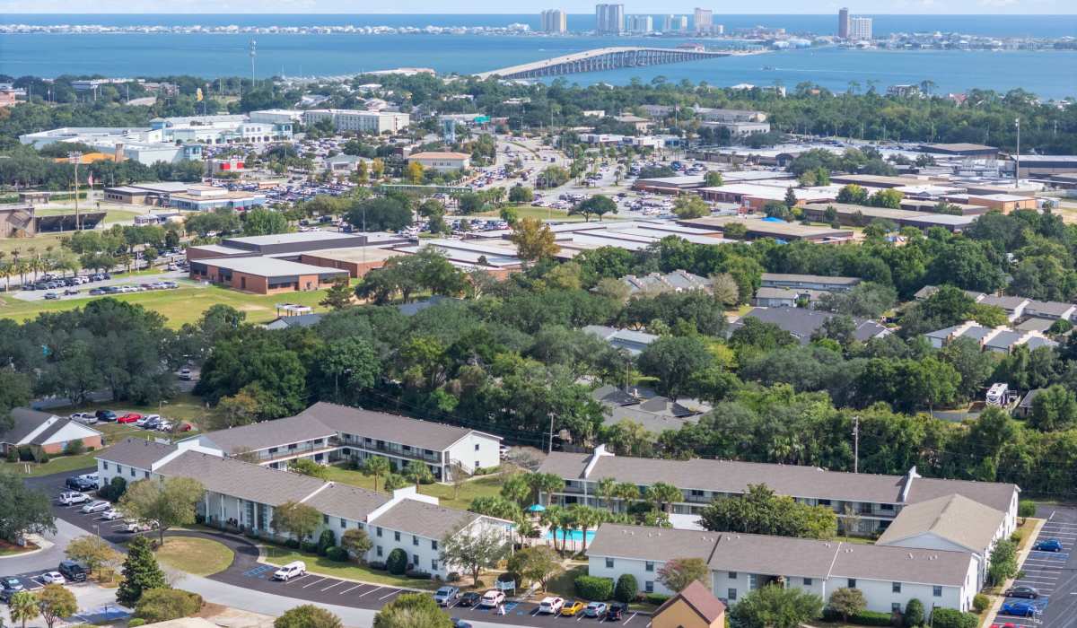 Community view with lush greenery and pool near Breeze Apartments in Gulf Breeze, Florida