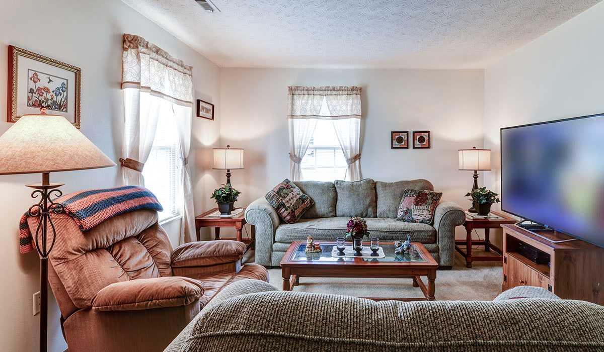 Cozy armchair with decorative throw at living room at Chartwell Greene in Mount Gilead, Ohio