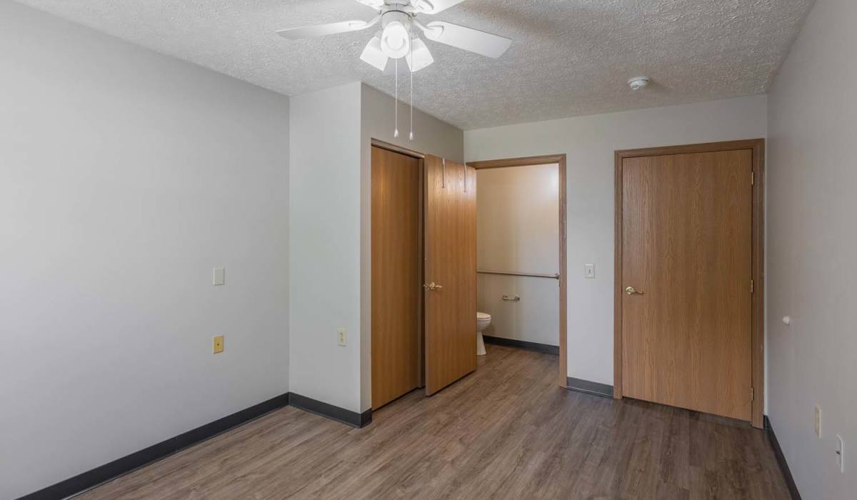 Spacious bedroom with wood-style flooring at Essex Place North in Sycamore, Ohio