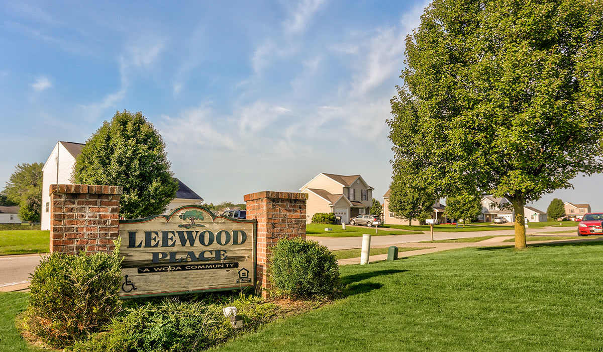 Community entrance sign with homes nearby near Leewood Place in Fremont, Ohio