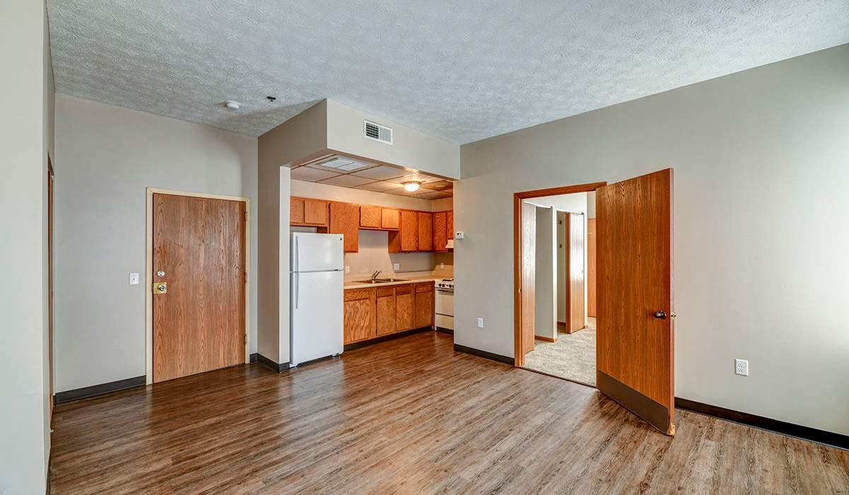 Open layout of the living room with wood-style flooring at St. Clairsville Courtyard in St. Clairsville, Ohio