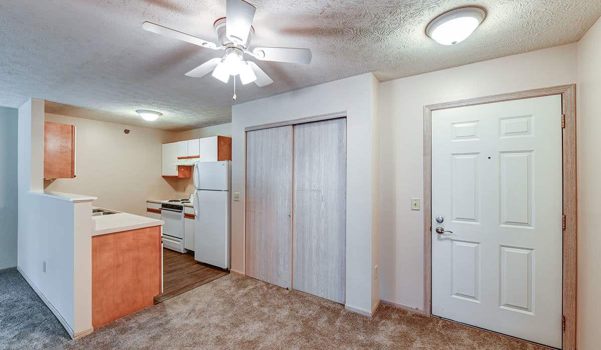 Open layout with ceiling fan and bright kitchen at Tall Trees in Tiffin, Ohio