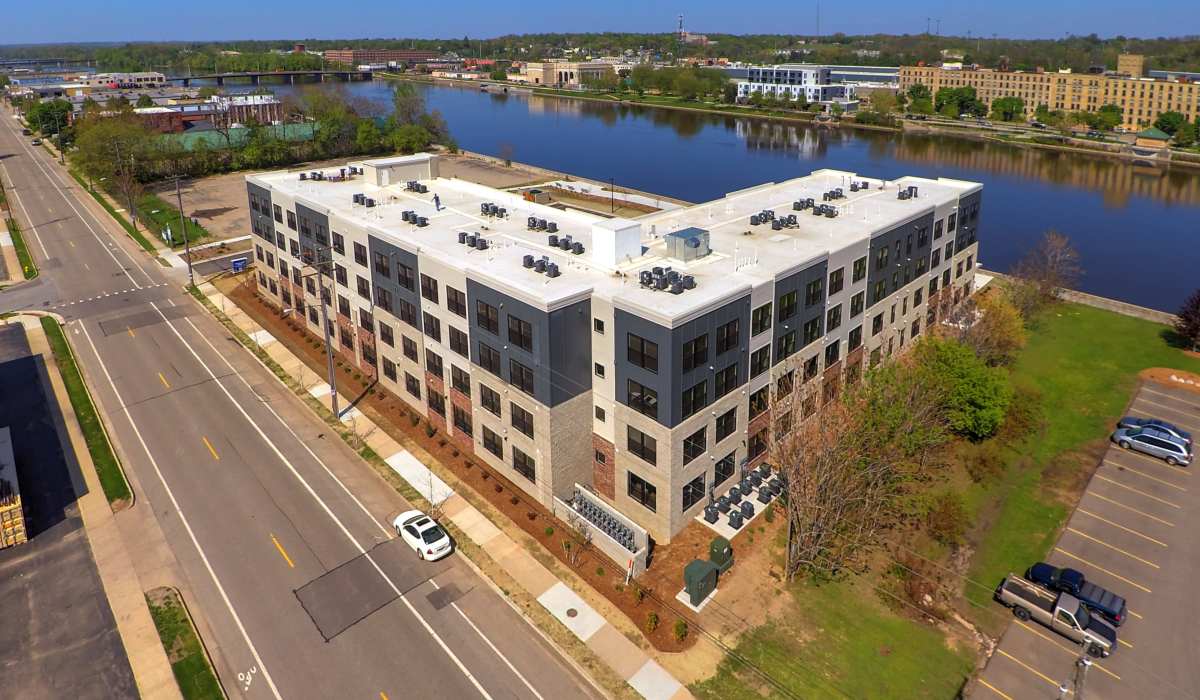 Modern apartment community with landscaped grounds and nearby water views at Grand View Place in Grand Rapids, Michigan