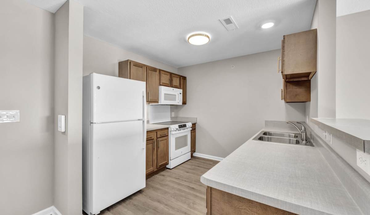 Open layout kitchen with white appliances at Newton Family Apartments in Canton, Ohio