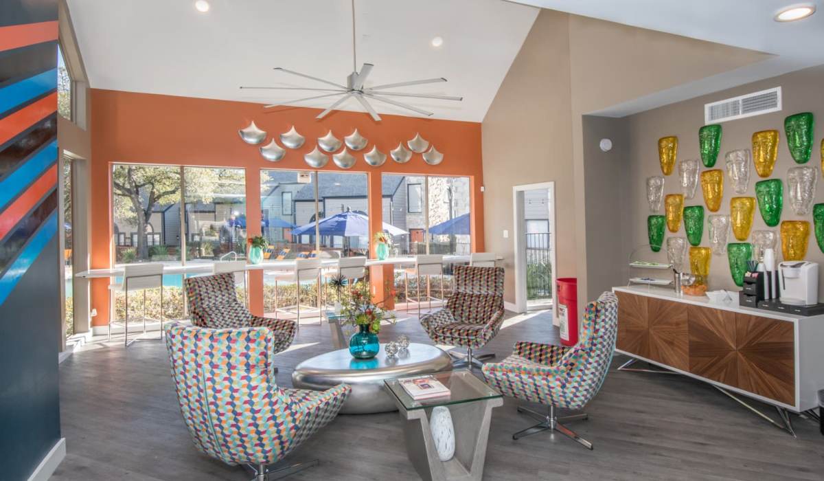 Colorful lounge with patterned chairs and pool view at The Lila at Oakgate in San Antonio, Texas