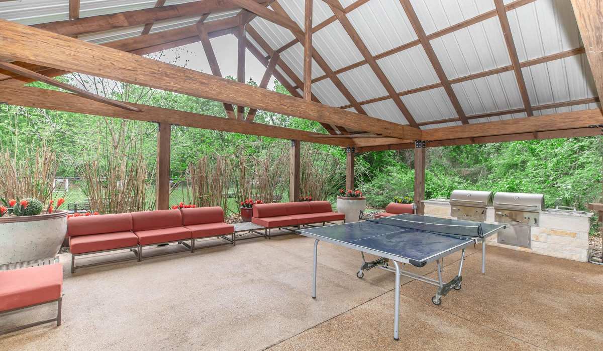 Modern ping pong table with seating and greenery at The Element in Bryan, Texas