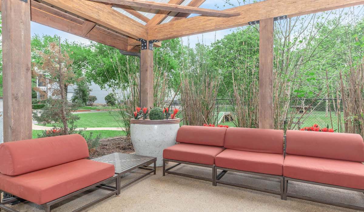 Garden style seating area with red cushions and planters at The Element in Bryan, Texas