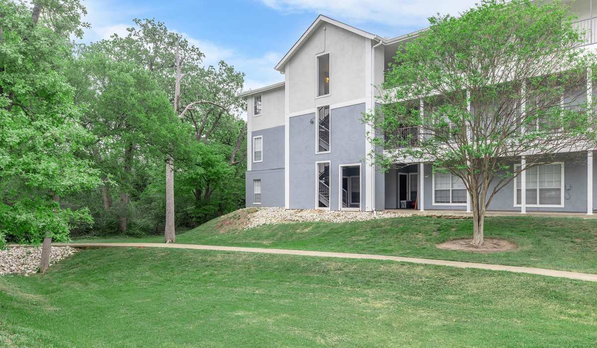 Green trees and grassy area with an upgraded building at The Element in Bryan, Texas