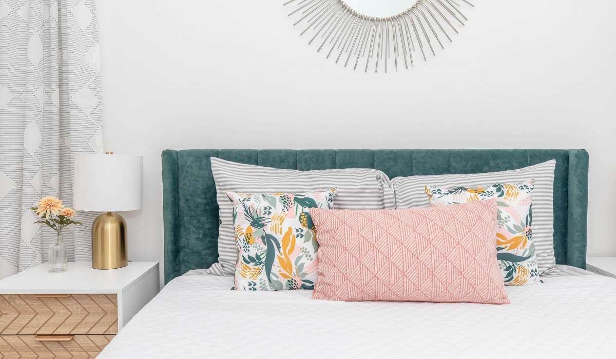 Pillows arranged on a bed with upgraded decor at The Element in Bryan, Texas