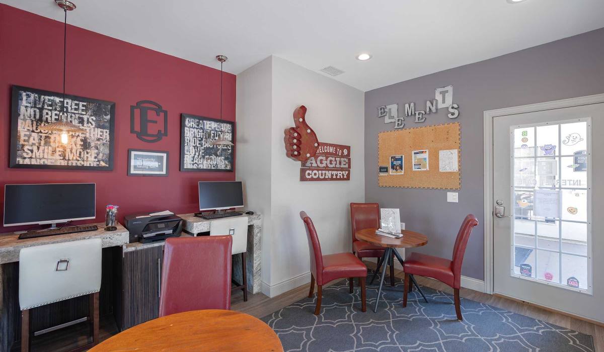 Modern red accent wall with framed art and decor at The Element in Bryan, Texas