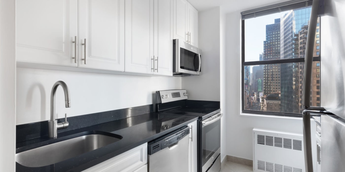 Black counter tops with stainless steel appliances in the kitchen at Carnegie Mews in New York, New York
