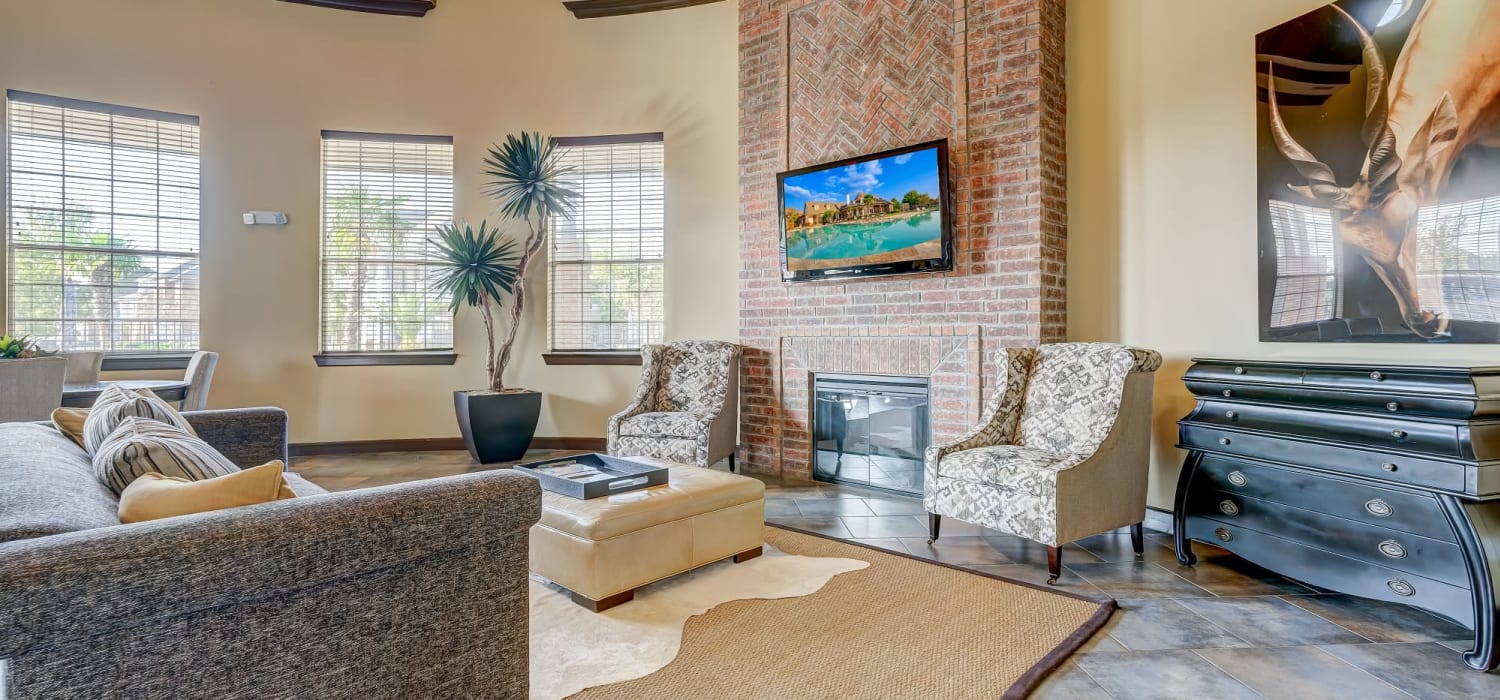 Lobby with seating and a fireplace at Chateau Mirage Apartment Homes in Lafayette, Louisiana