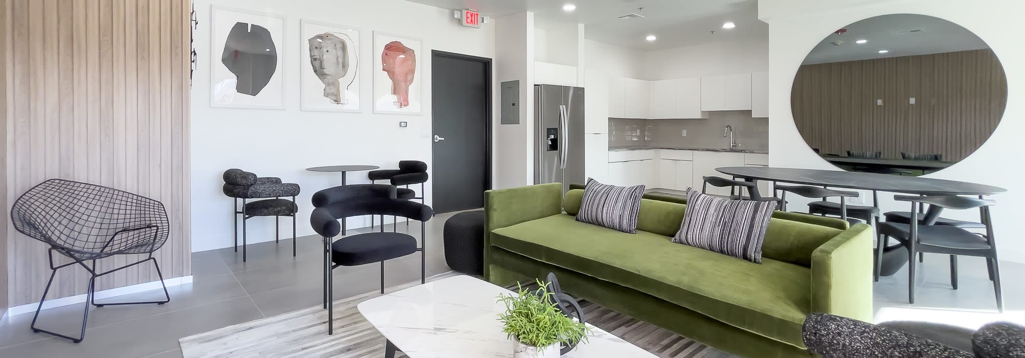 Resident lounge area with a kitchen and tables to sit at at The Charleston Apartments in Phoenix, Arizona