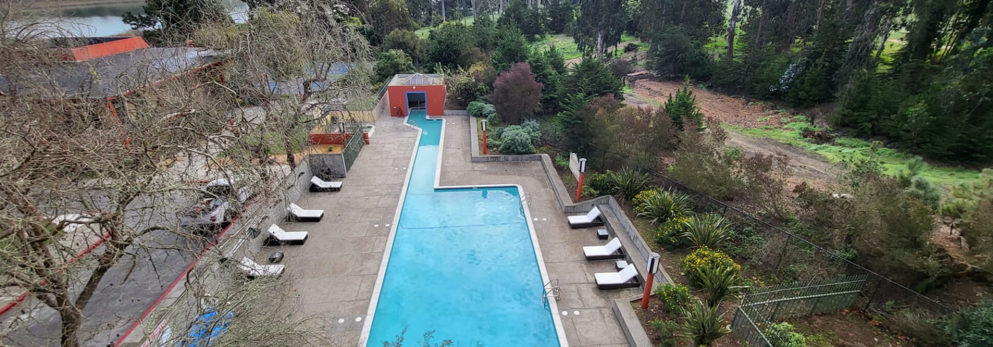Lounge chairs by the resort-style swimming pool at Lakewood Apartments at Lake Merced in San Francisco, California