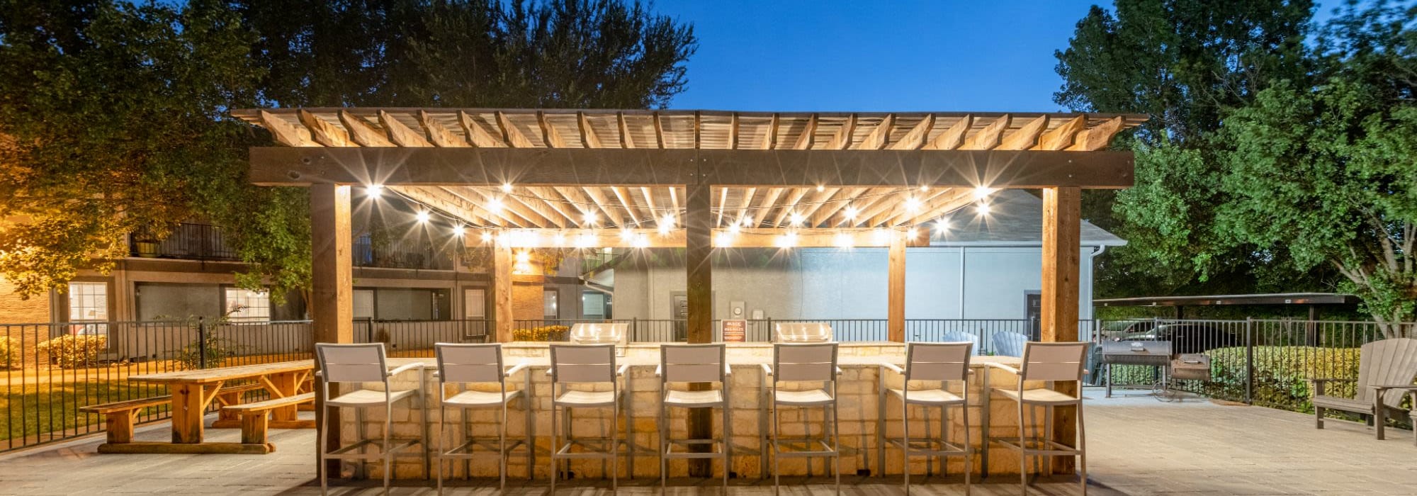 Outdoor grill station with picnic table at The Rustic of McKinney in McKinney, Texas