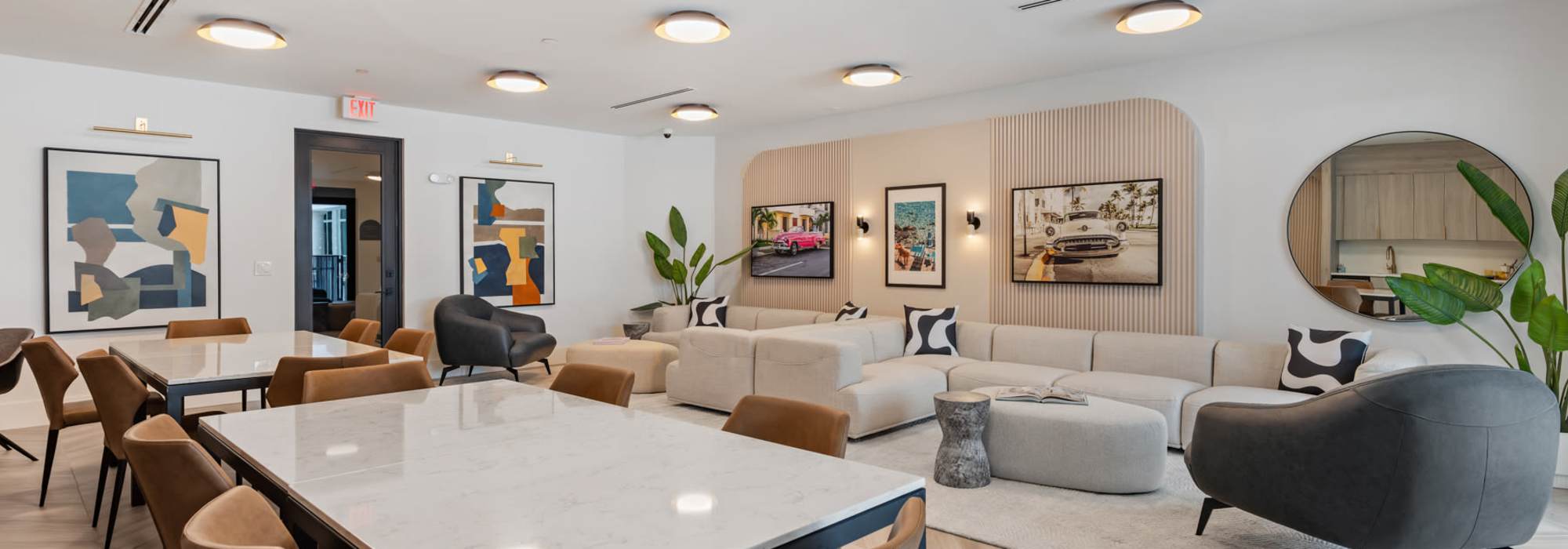 Comfortable couches and large tables with chairs in the clubhouse at Cordoba in Doral, Florida