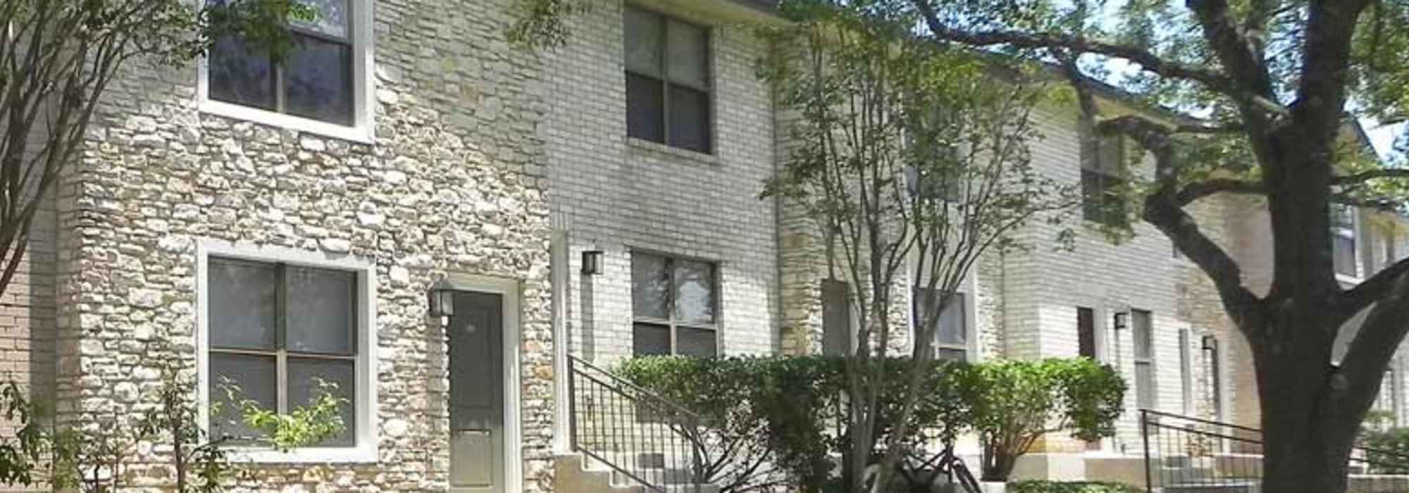 View of the apartment building with trees all around at Highcrest in San Marcos, Texas