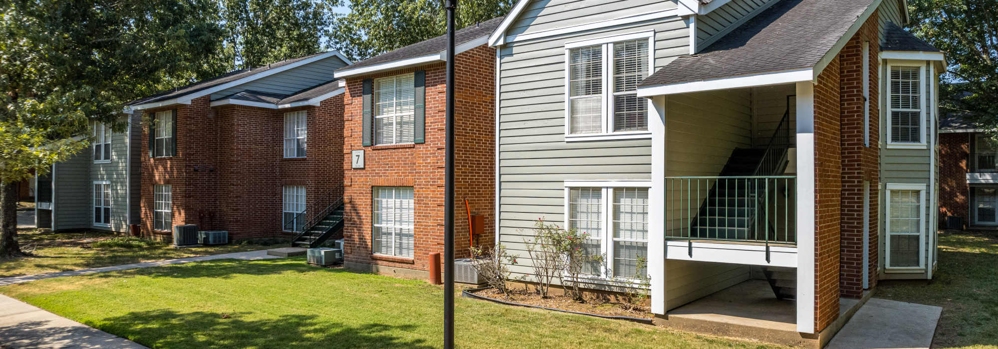Exterior view of the apartment building with stairs leading to the first floor at The Willows in Shreveport, Louisiana