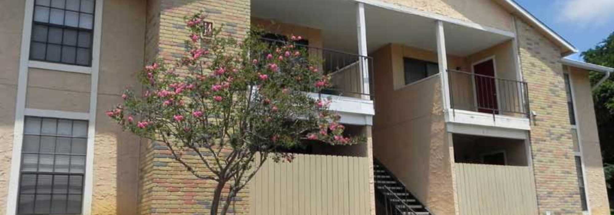 Exterior view of the building with stairs and a private balcony at Highcrest in San Marcos, Texas