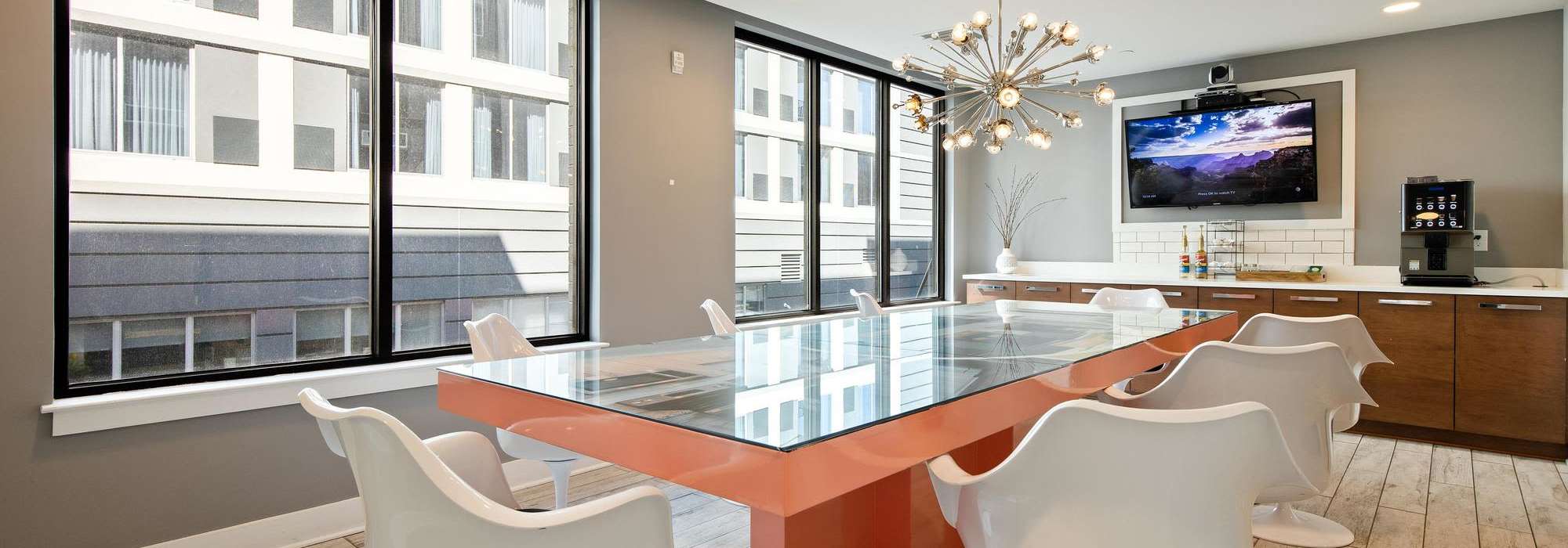 Resident clubhouse with luxury lighting and conference table at The Dartmouth North Hills in Raleigh, North Carolina
