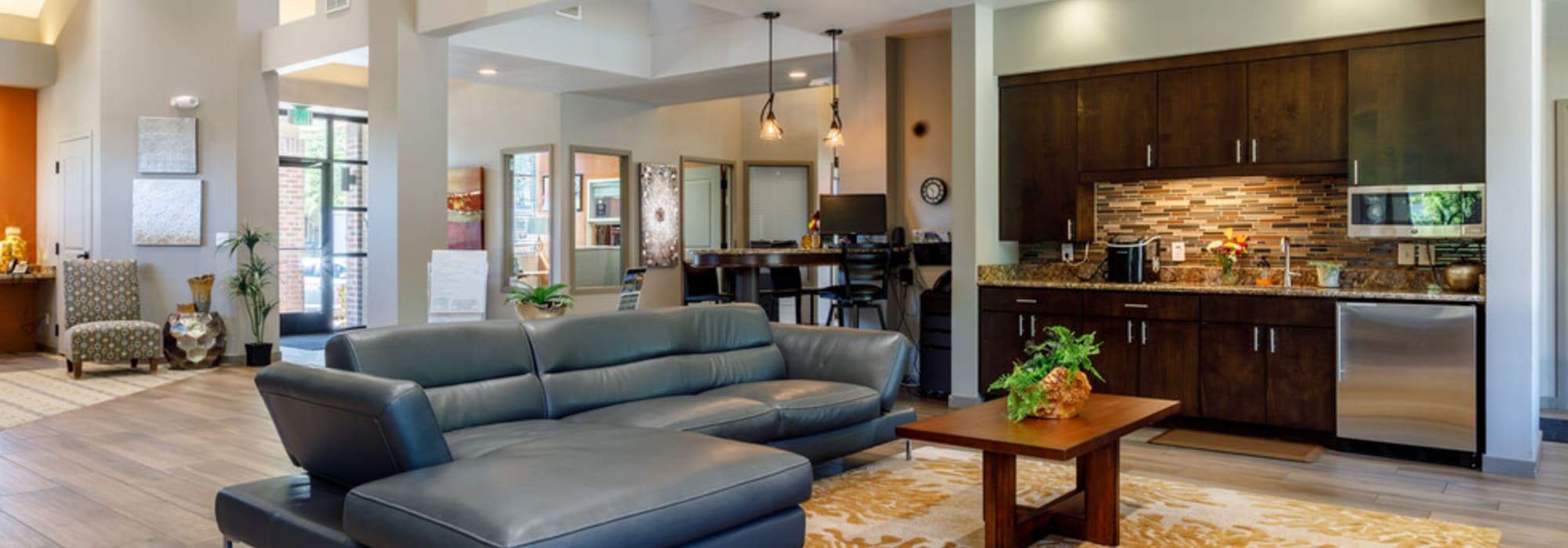 Community living room with open kitchen at UTE Creek Apartments in Longmont, Colorado