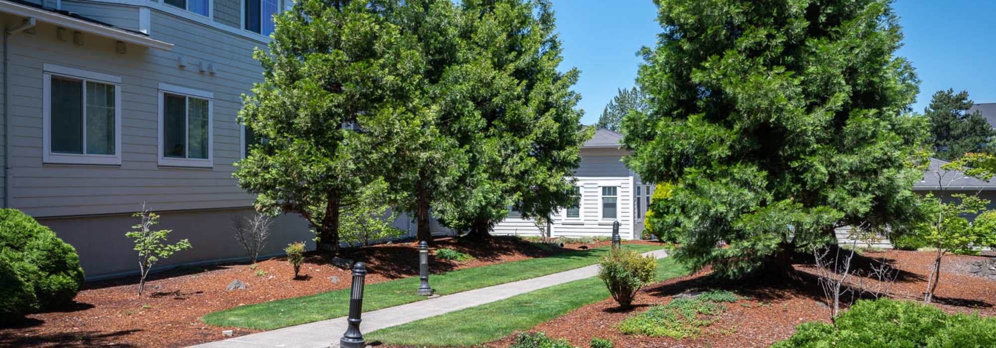 Community grassy lawn and sidewalk at Chinook Way Apartments in Fairview, Oregon