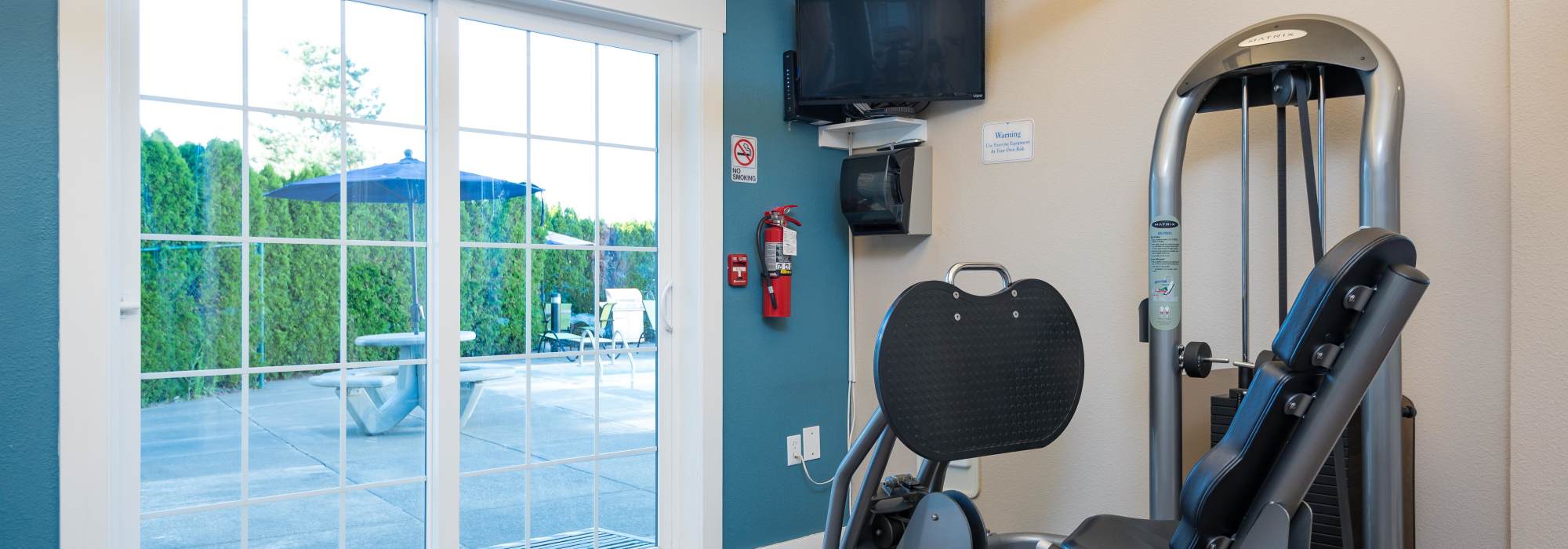 Fitness center with television at Chinook Way Apartments in Fairview, Oregon