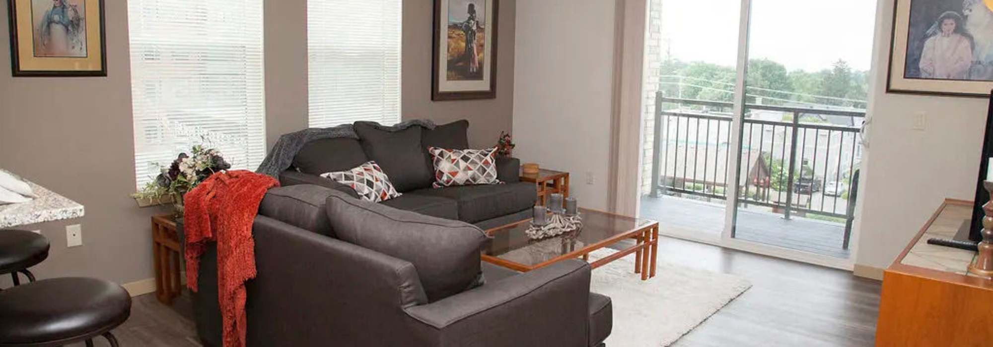 Living room with a door leading to patio at Hoff Mall and Hoff Apartments in Mount Horeb, Wisconsin     