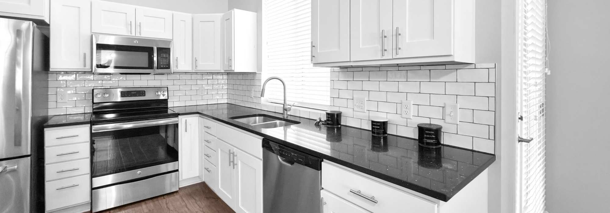 Modern kitchen with granite countertops at Cityville on 9th in Des Moines, Iowa