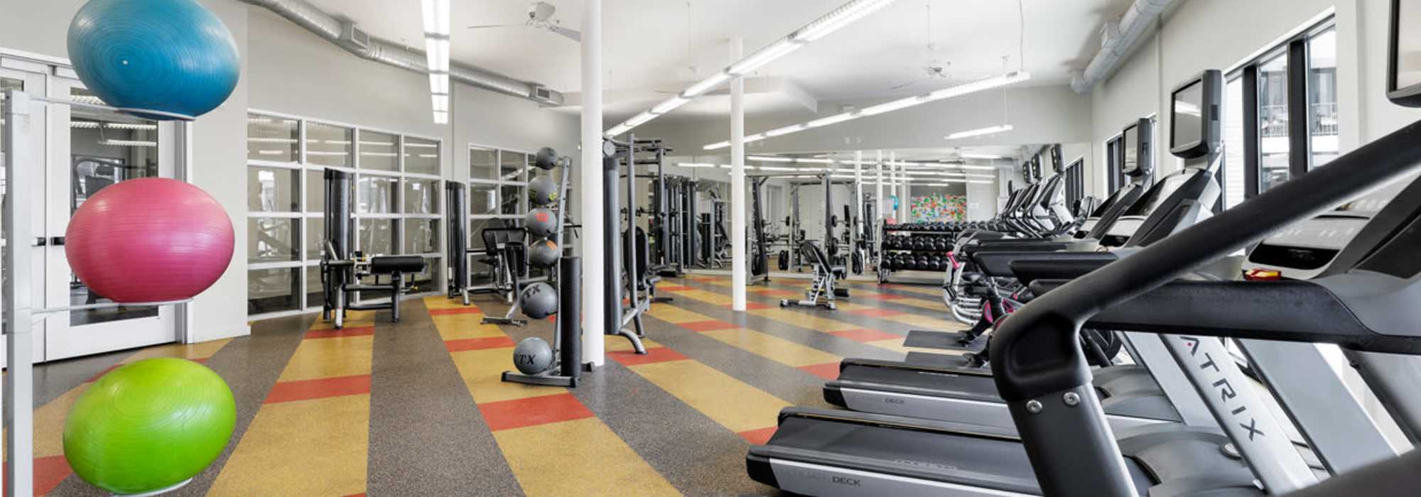 Bright fitness center with various exercise equipment at Corazon in Austin, Texas