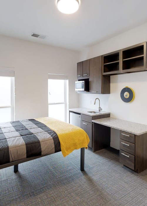 Large bedroom with tons of natural light and small kitchen area at The View on Pavey Square in Columbus, Ohio