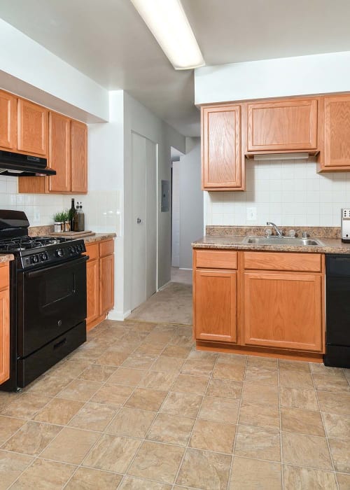 Kitchen with black appliances and colorful cabinets at Landmark Glenmont Station in Silver Spring, Maryland