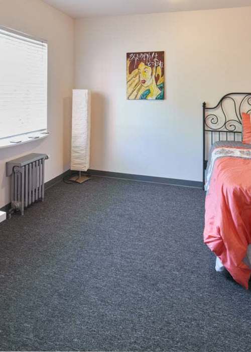 An apartment bedroom with soft carpet at Milepost 5 in Portland, Oregon