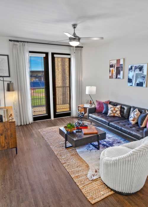 A furnished living room with a ceiling fan at Fieldhouse Apartments in Lawrenceville, Georgia
