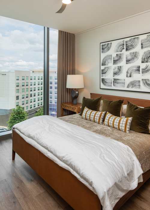 Bedroom with floor-to-ceiling windows and tall ceilings at The Eastern in Raleigh, North Carolina