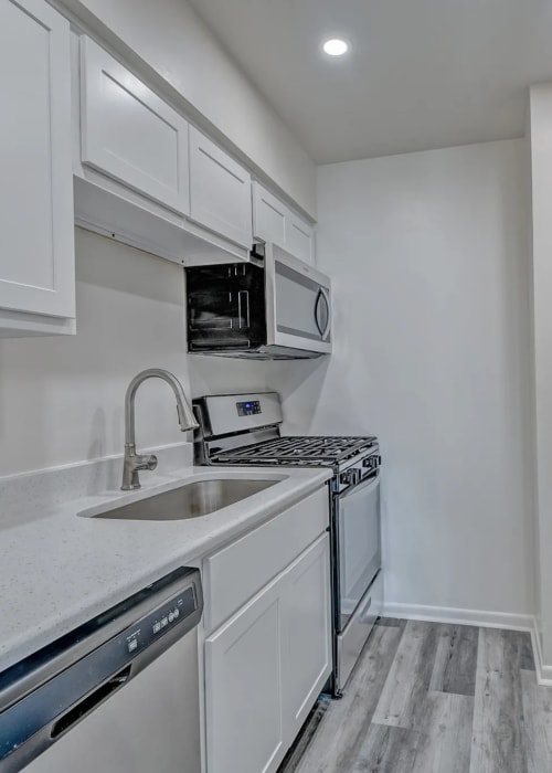 Modern kitchen with white wooden cabinets, microwave and stainless-steel appliances at Woodside Village in Valparaiso, Indiana