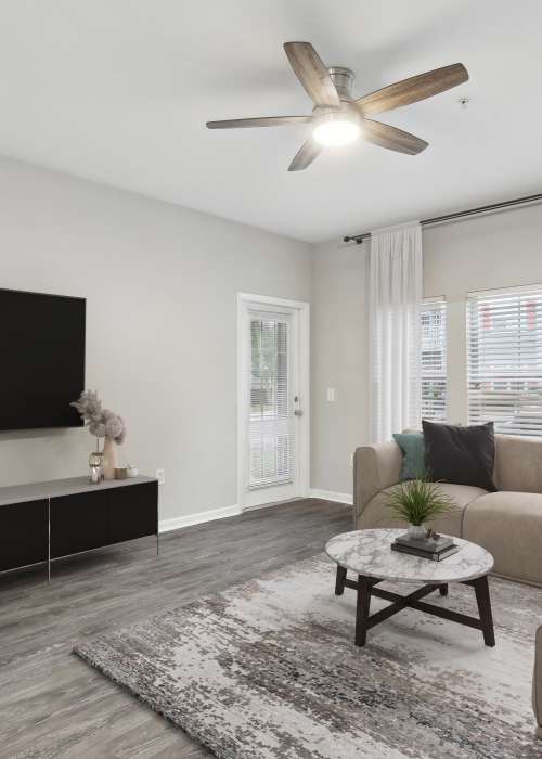 Living room with coffee table, large TV and windows at The Haven At West Melbourne in West Melbourne, Florida