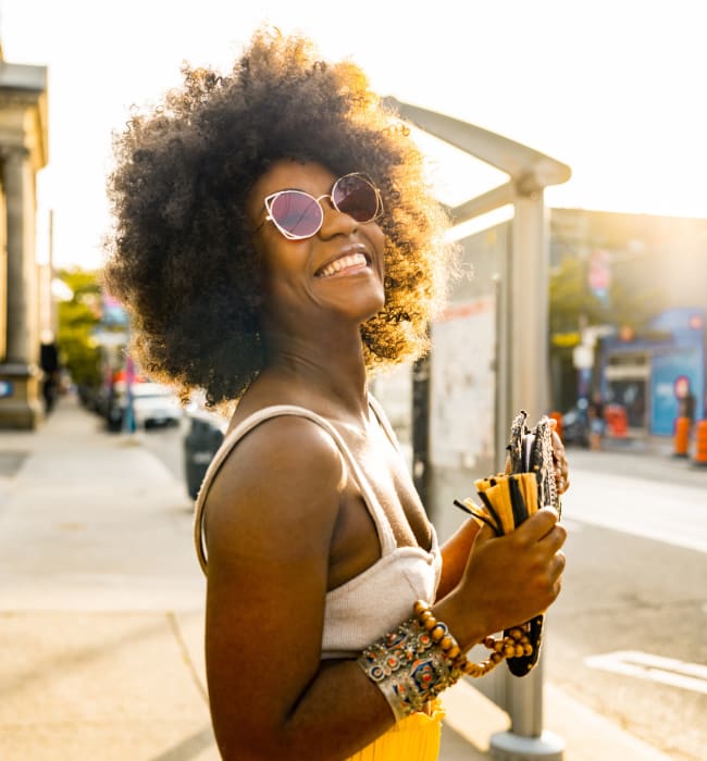 Resident smiling in the sunlight at bus stop near Marq at Crabtree in Raleigh, North Carolina