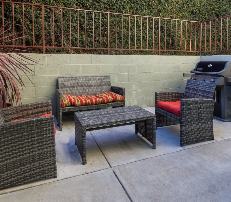 Outdoor cushioned sitting area near BBQ grill at The Diplomat in Studio City, California