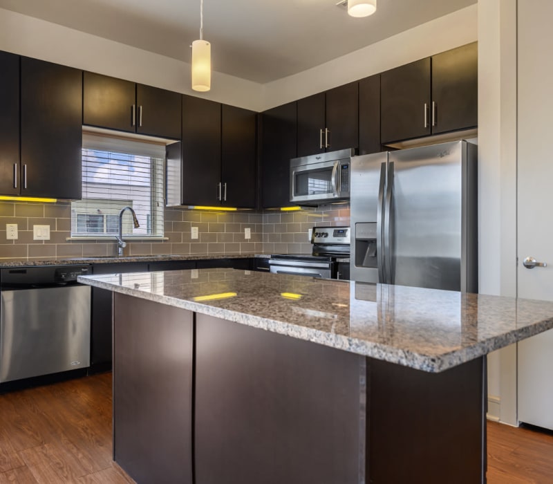 Modern style kitchen with stainless steel appliances and granite countertops at Sabina in Austin, Texas